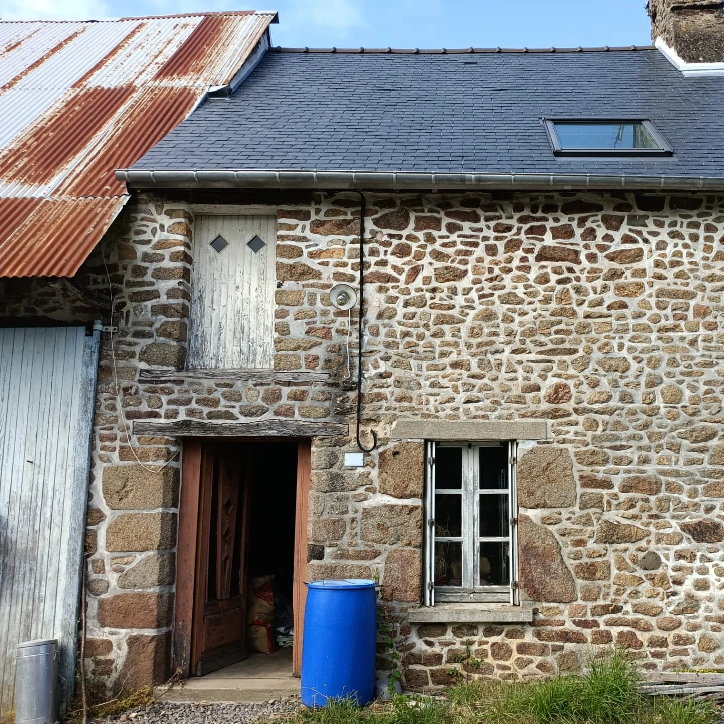 Façade en pierre de granit rejointoyée à la chaux, toiture en ardoise